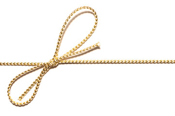 Golden satin rope parallel to frame with knotted bow gift ribbon wrap for Christmas present with intricate shine details isolated cut out top view on simple plain white background.