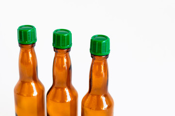 Close-up corner shoot of three line positioned small alcohol bottles brown colored