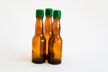 Front shoot of three angled positioned small alcohol bottles brown colored