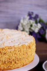 Homemade cake with crushed nuts and flowers on background