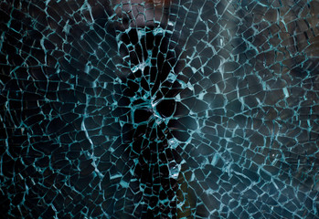 Broken glass of a shop window of a clothing store with unfocused background