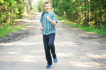 Obraz premium teenager boy walking in the forest alone in the summer day