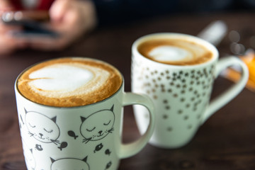 Cappuccino coffee. Beautiful coffee in cute mugs. Delicious coffee in the cafe