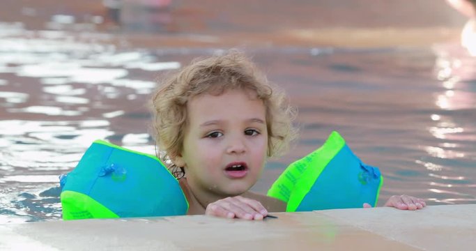 Child wearing inflatable armbands at the swimming pool