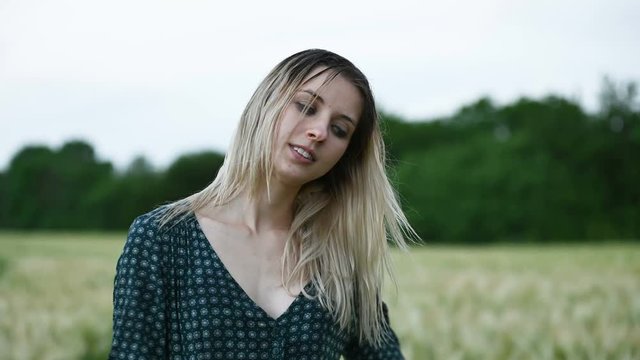 Portrait of a happy attractive Caucasian blonde girl with wet hair during a rain on the nature outdoor on a wheat field. Happiness hope flirting and coquetry