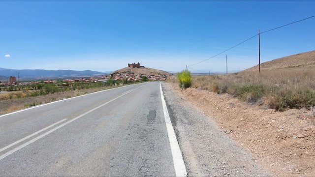 a paved road approaching La Calahorra town, Province of Granada, Andalusia, Spain