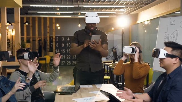 Team of young business man and woman using vr virtual reality glasses in the modern office.