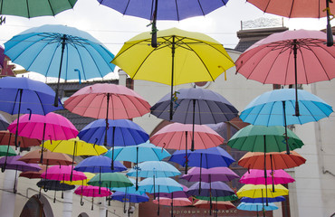 Obraz na płótnie Canvas Colorful umbrellas background. Colorful umbrellas in the sky. Street decoration.