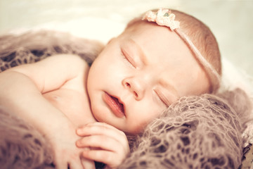 Newborn baby girl sleeping in a basket. Concept shooting newborns, innocence