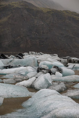 The Solheimajokull Glacier in Iceland showing icebergs and calved ice in the lagoon as ice calves...