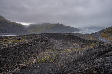 The Solheimajokull Glacier in Iceland showing icebergs and calved ice in the lagoon as ice calves...