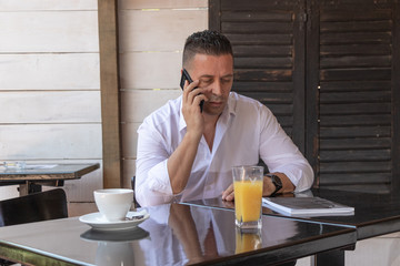 Fototapeta na wymiar man drinking coffee in cafe and speaking on the phone