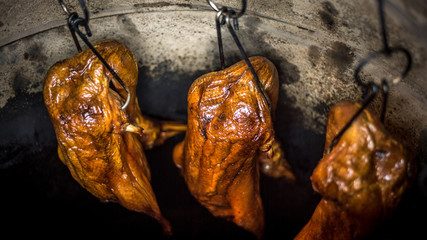 Close-up of a roasted duck meat in huge clay oven of an asian restaurant.