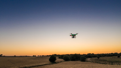 Fototapeta na wymiar Aerial view of drone flying with digital camera over a field with sunset