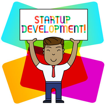 Conceptual hand writing showing Startup Development. Concept meaning efficiently develop and validate scalable business model Smily Man Standing Holding Placard Overhead with Both Hands