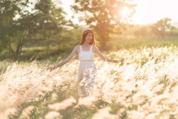Fototapeta na wymiar Beauty Girl Outdoors enjoying nature. Beautiful Teenage Model girl in white dress running on the Spring Field, Sun Light.