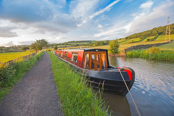 Narrowboat moored on a British canal in rural setting