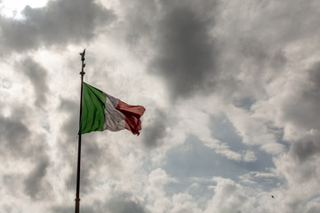 Italian flag in the wind with cloudy sky on background 