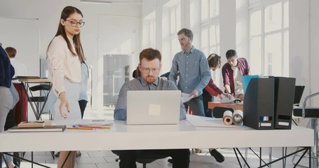 Stressed young businessman suffers panic attack at work, throwing documents up and walking away from office RED EPIC. - Powered by Adobe