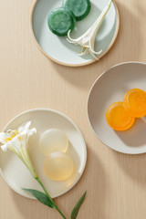 Top view of organic spa skincare products with salt, flowers, natural soap, towels and pumice stone