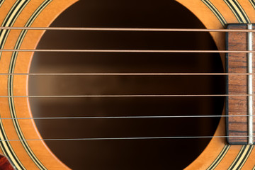 close macro view of the six frets  and sound hole on an acoustic wooden  guitar