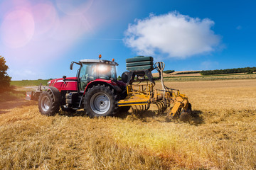 farmer plowing fields after summer grain harvest