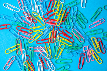 multi-colored paper clips on a blue background.