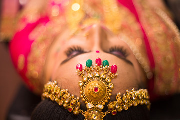 Beautiful Asian Indian Bride Wearing Ethnic Traditional Outfit And heavy Gold Jewellery Necklace head shot wedding day