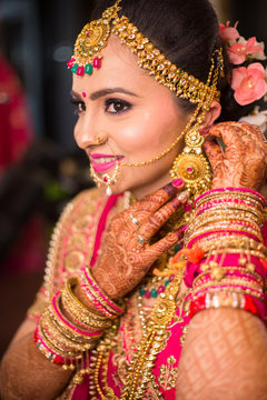 Portrait Of Beautiful Asian Indian Bride Wearing Ethnic Traditional Outfit And Heavy Gold Jewellery Necklace Smiling Wedding Day