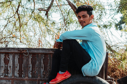 Indian male model posing for the photo while sitting on the land
