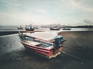 Fisherman boats at low tide with romantic and vintage atmosphere