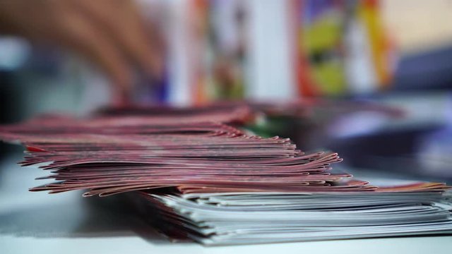 Business Brochure in Documents concept : Businessman hands working in stacks brochures paper files for checking document achieves reports on busy work desk office