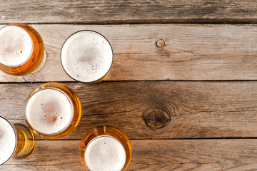 Overhead shot of beer glasses on wooden table.