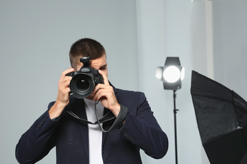 Professional photographer taking picture in modern studio