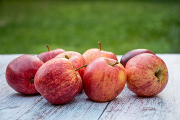 Organic ripe apples on a wooden table in the garden. Cooking ingredients. Harvest.