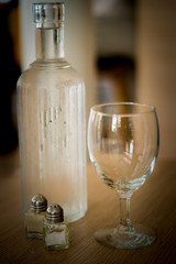 Bottle of water with empty wine glass in brown vintage setting