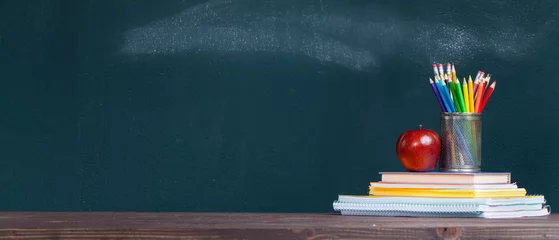 Wall murals School Pencil tray and an apple on notebooks on school teacher's desk.