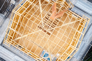 Wooden roof truss beams during construction building of a house aerial view - obrazy, fototapety, plakaty