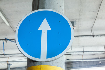 White arrow on blue background of round traffic sign. Blue road sign, indicates the mandatory...