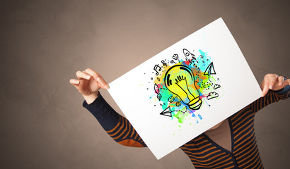 Person holding a paper with a drawn colorful idea concept