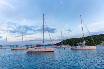 Fototapeta premium calm bay at evening with moored yachts