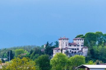 Fototapeta na wymiar Yellow fields of rape on the hills of Friuli. Cassacco and its castle
