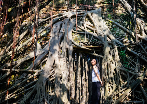 Young girl stands before tree house