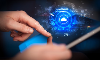 Hand holding tablet with cloud storage technology concept