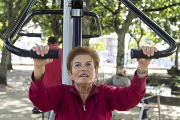 happy senior woman doing exercises and gymnastics outdoors