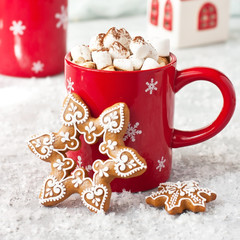 Red mug filled with hot chocolate, marshmallows and gingerbread cookies  on  light background