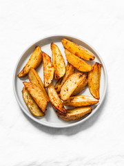 Simple rustic baked potato slices on a light background, top view