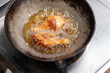 Fry the chicken in a pan with boiling oil.