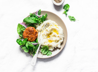 Chicken cutlet with cauliflower puree and fresh spinach on light background, top view