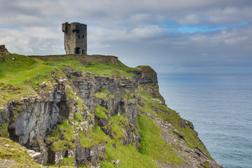 Fototapeta na wymiar Tower ruin over steeply cliffs at Irish West coast